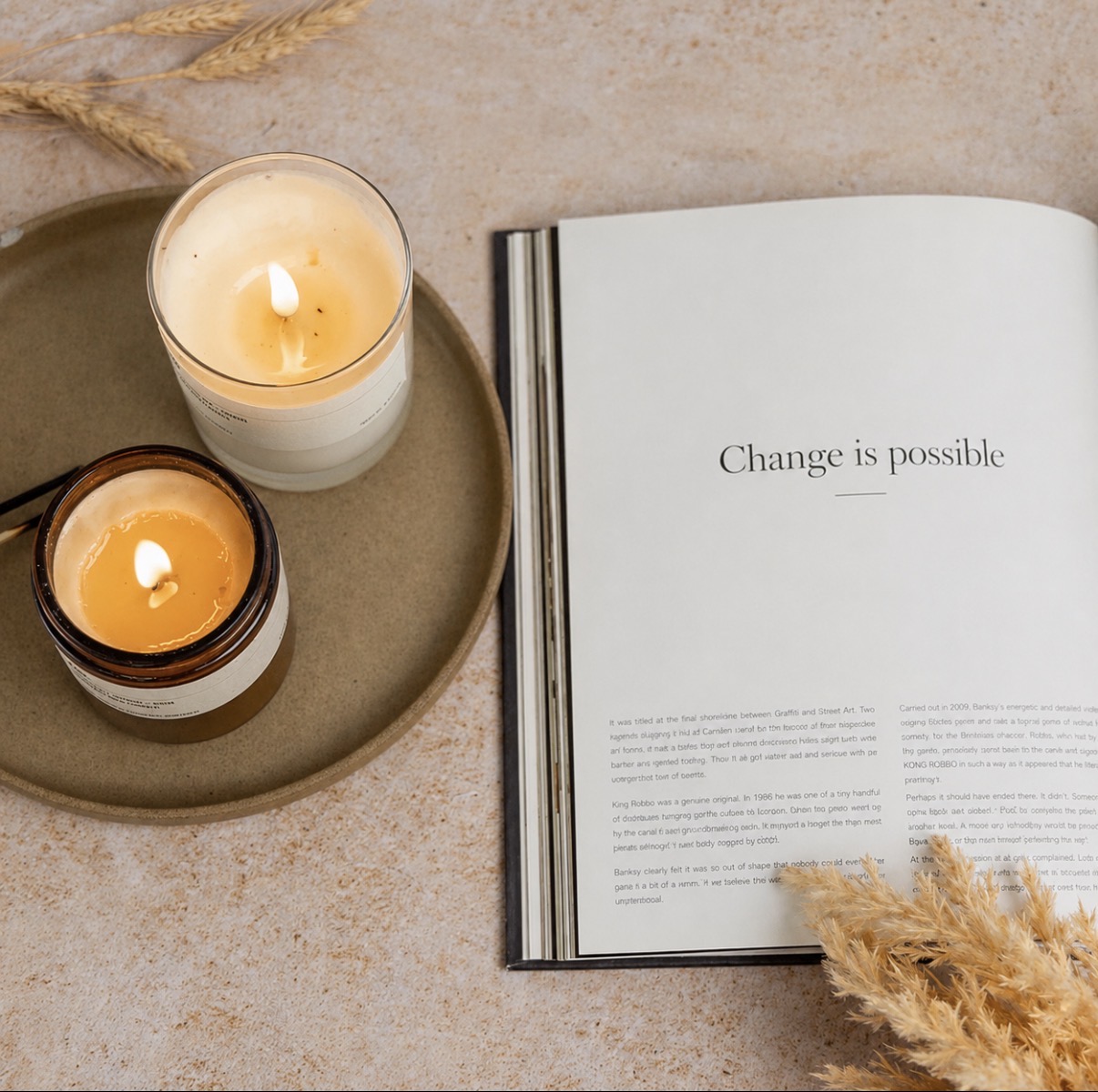 Candles beside an open book with the words Change is possible
